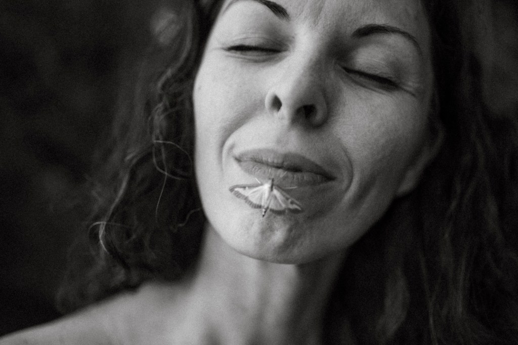 Artist Jelena Medić close up with the butterfly on her lips